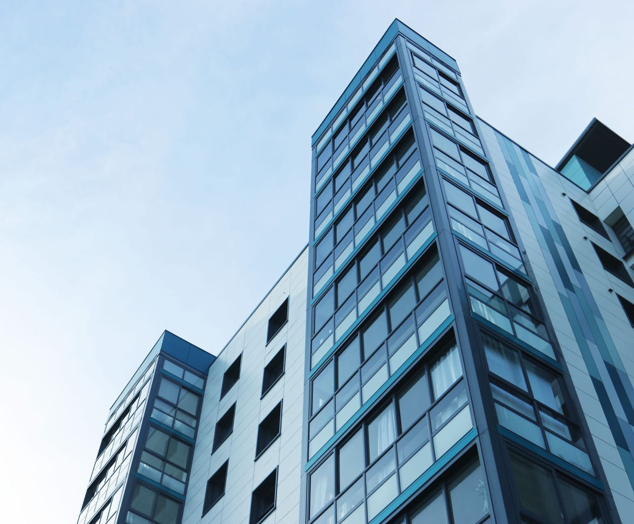 Looking up towards apartment building and blue sky