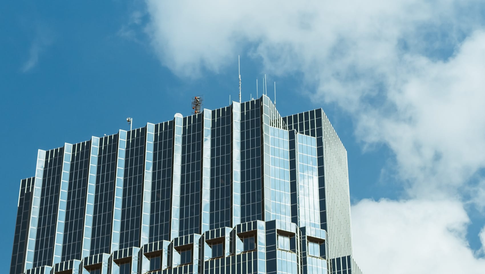 Looking up at building with blue sky and clouds