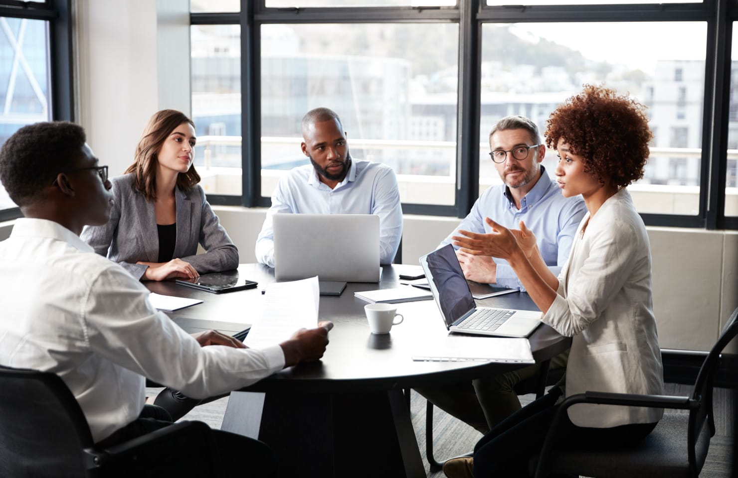 5 adults meeting in a conference room