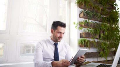 Businessman working on digital tablet while sitting at office desk