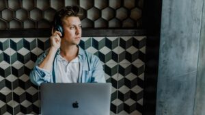 Man wearing headphones and working on his Mac computer